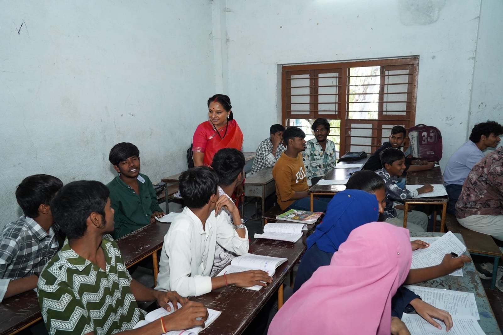 Kalvakuntla Kavitha interacting with students and teachers during her visit to Kacheguda High School in Hyderabad as part of the Jagruti Janambata program